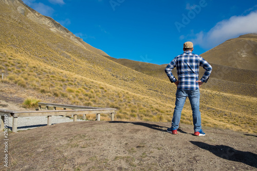 Hipster man traveller at yellow hill Lindis Pass, New Zealand. .