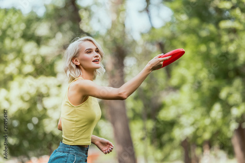 Tableau sur toile attractive girl throwing frisbee disk in park