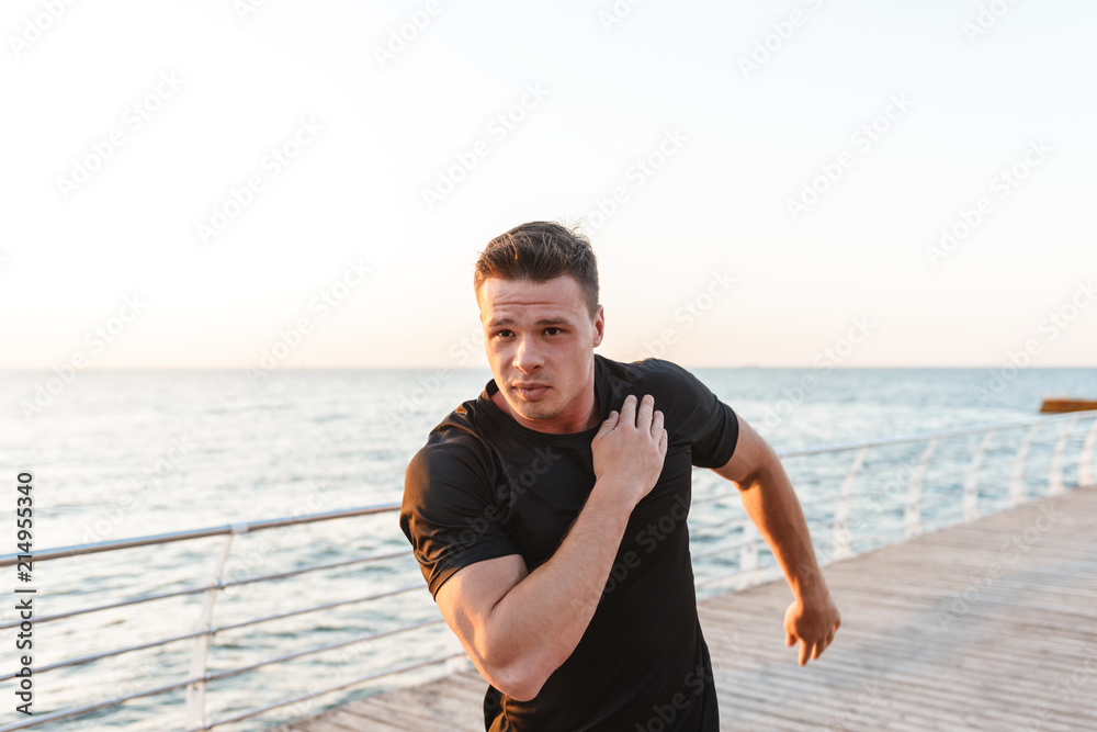 Focused young sportsman doing stretching