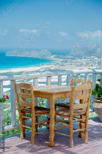 Wooden table in cafe with mountains and sea on background  Falassarna region  Crete  Greece