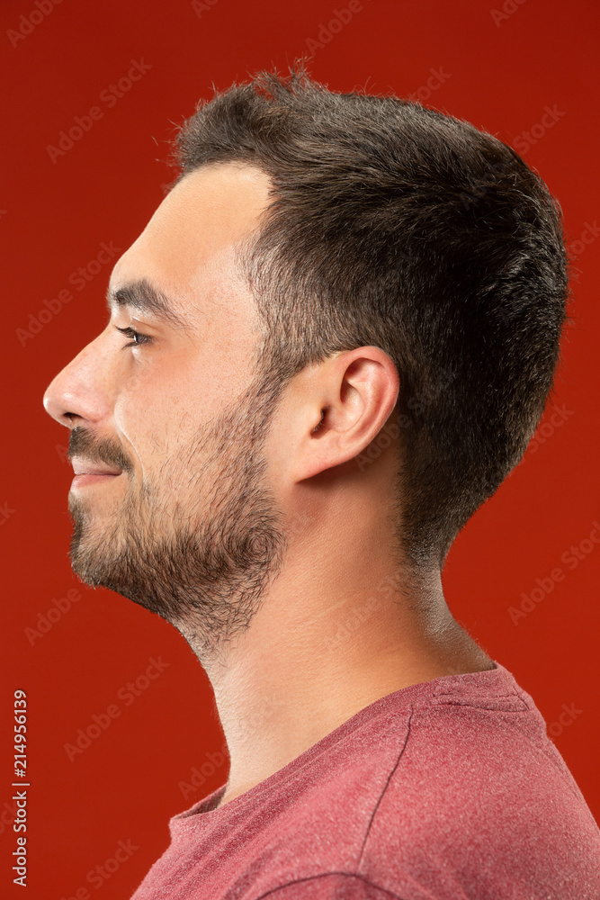 The happy business man standing and smiling against red background. The happy business man standing and smiling against red background.