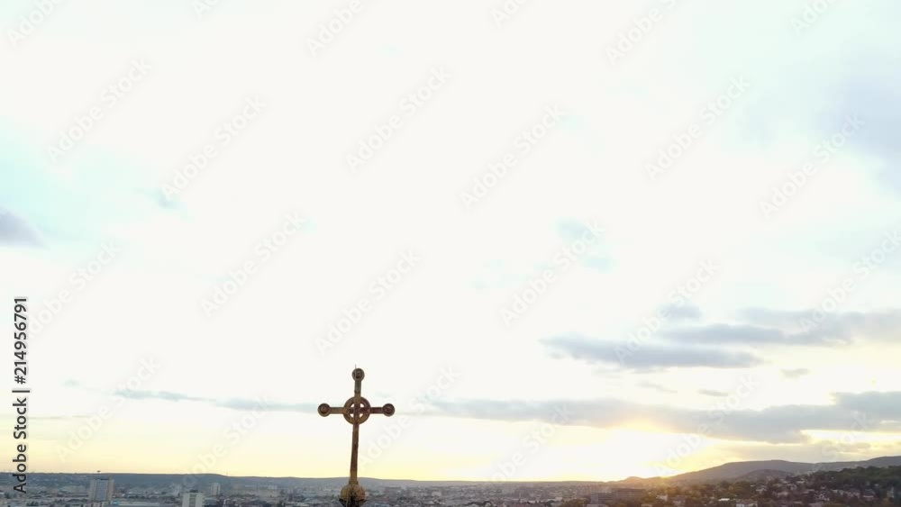 Arial POV rising and orbiting the steeple on a historic old church in the middle of the city with the sun setting in the background. Arial POV rising and orbiting the steeple on a historic old church in the middle of the city with the sun setting in the background.
