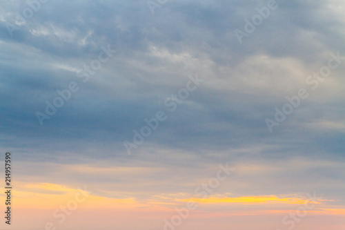 Summer sunset in the cloudy sky above the sea