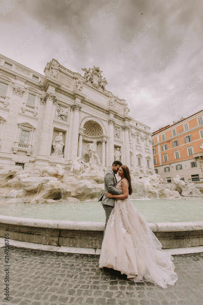 Young wedding couple by Trevi fountain in Rome