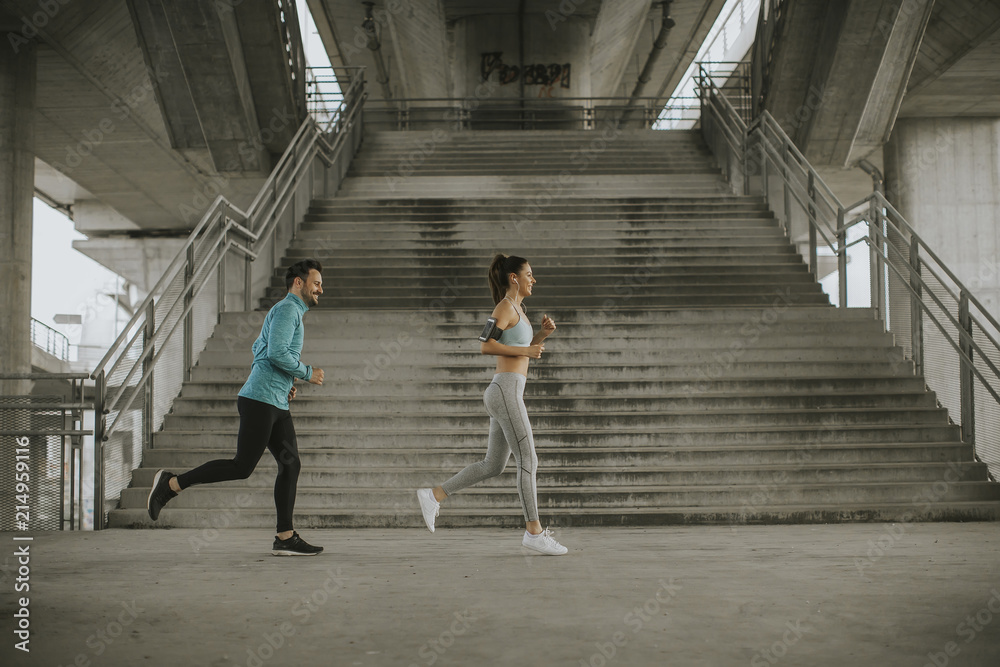 Young couple running in urban enviroment Young couple running in urban enviroment