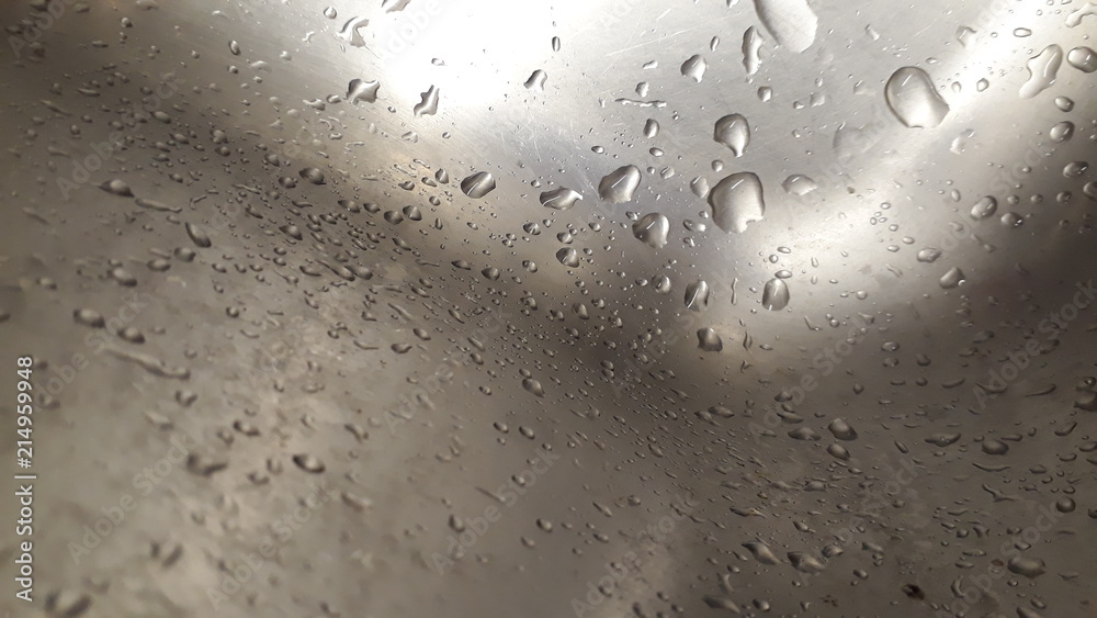 Drops of water scattered inside a gray steel sink