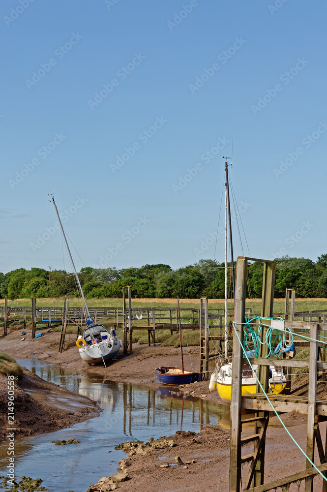 Yachts moored at low tide in Steeping River, Gibraltar Point,UK Yachts moored at low tide in Steeping River, Gibraltar Point,UK