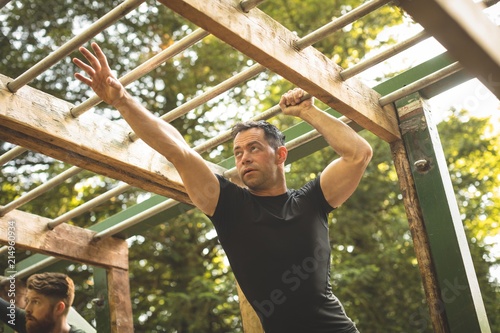 Fit man climbing monkey bars