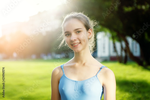 Portrait of ballet dancer dancing outdoor. Young ballerina in blue sportwear. Portrait of young lovely pretty beautiful girl in the park.
