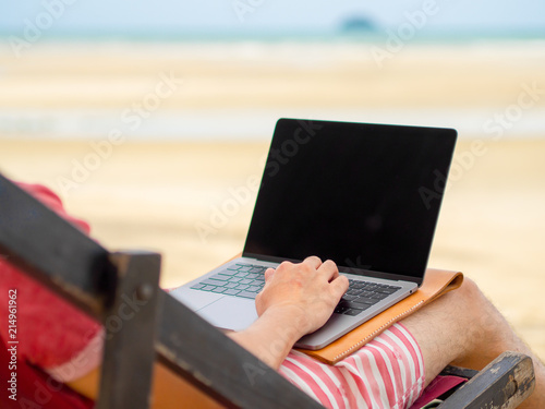Man relax on camp bed and working online.