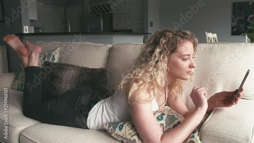 Cute blonde woman having video call with a friend in a modern home interior