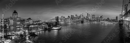 Brooklyn, Brooklyn park, Brooklyn Bridge, Janes Carousel and Lower Manhattan skyline at night seen from Manhattan bridge, New York city, USA. Black and white wide angle panoramic image.