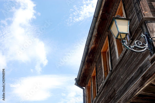 Facade of an old wooden building with a lantern on a blue sky background in Nessebar, Bulgaria
