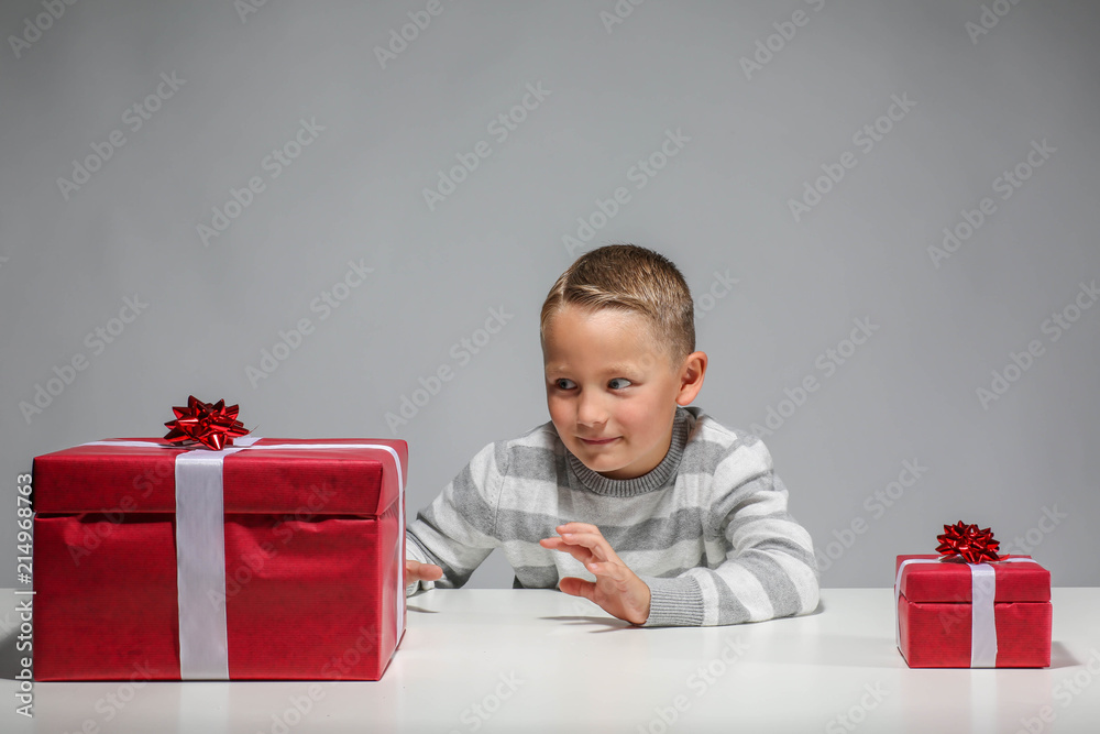 Little boy with a small an a big Xmas-present is pointing the big ...