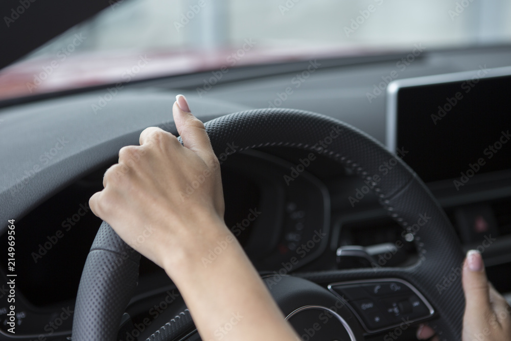 The hand of a girl with a stylish manicure lies on the handlebars in a saloon car. The hand of a girl with a stylish manicure lies on the handlebars in a saloon car.