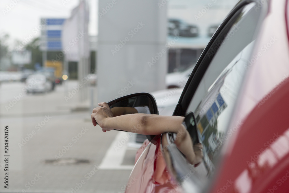 Side view of woman sitting inside a car and looking out of the window