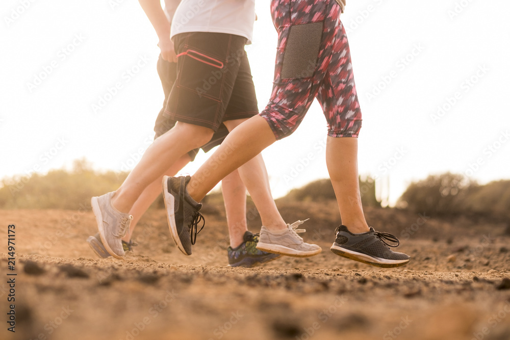 friends running together in a desert ground tropical landscape. summer sun in backlight for caucasian nice people in sport activity. enjoying the active lifestyle