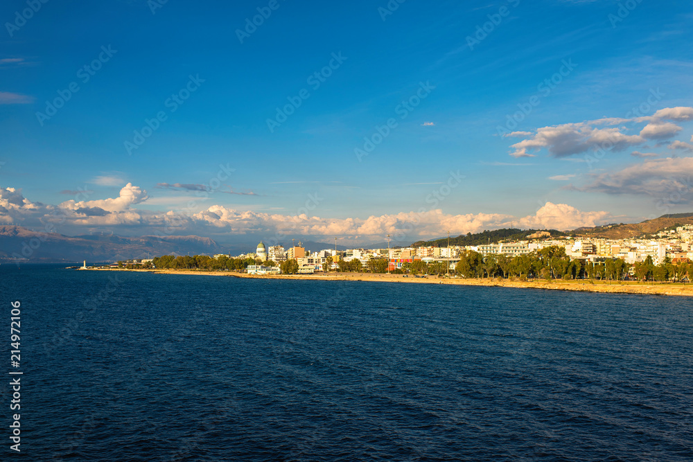 View from the ferry ship on the Rion-Antirion bridge and port of Patra city at sunset in the Ionian Sea, Greece