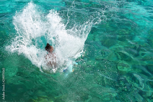 Young man jumping into water 