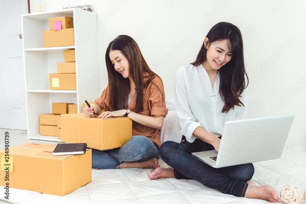 Young Asian woman startup small business entrepreneur SME distribution warehouse with parcel mail box. Owner home office concept. Online marketing and product packaging and delivery service. Young Asian woman startup small business entrepreneur SME distribution warehouse with parcel mail box. Owner home office concept. Online marketing and product packaging and delivery service.