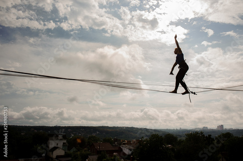 Young active woman walking on the slackline rope