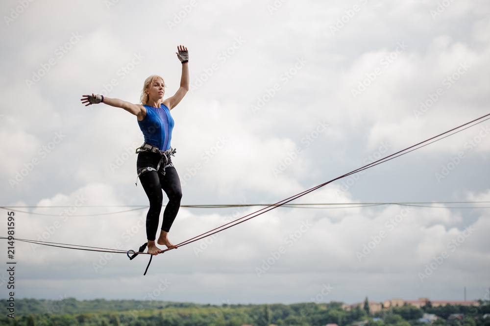 Young woman balancing on the slackline rope Young woman balancing on the slackline rope