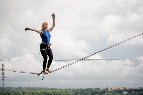 Young woman balancing on the slackline rope