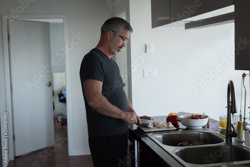 Man cutting vegetables in kitchen photo