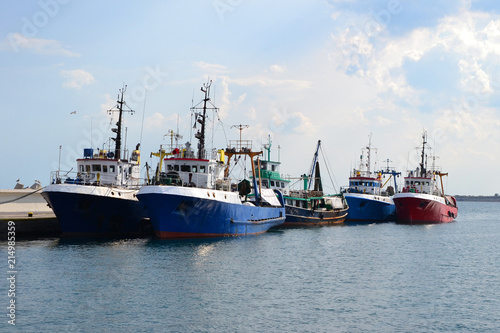 Fishing boats in harbour and blue sea.
