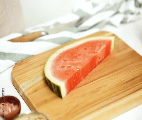 Time lapse. Slicing watermelon in cubes for preparing watermelon appetizers dipped in chocolate and sprinked with sea salt and almonds photo