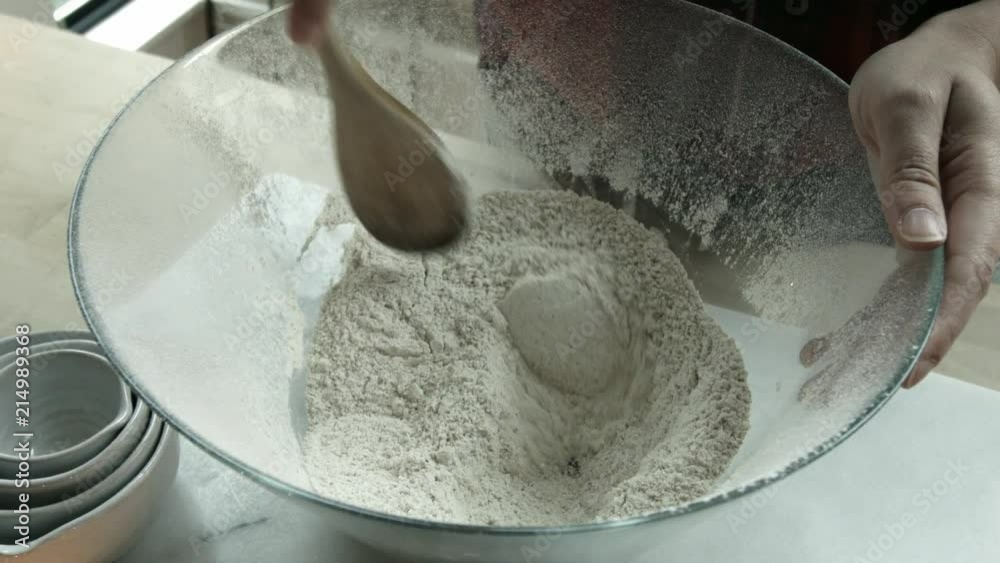 Close up of hands stirring flour in the kitchen to make bread. Close up of hands stirring flour in the kitchen to make bread.