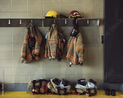 Firefighter hat and gear hanging in the fire stastion photo