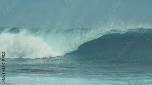 CLOSE UP: Breathtaking blue barrel wave crashing towards the tropical shore.