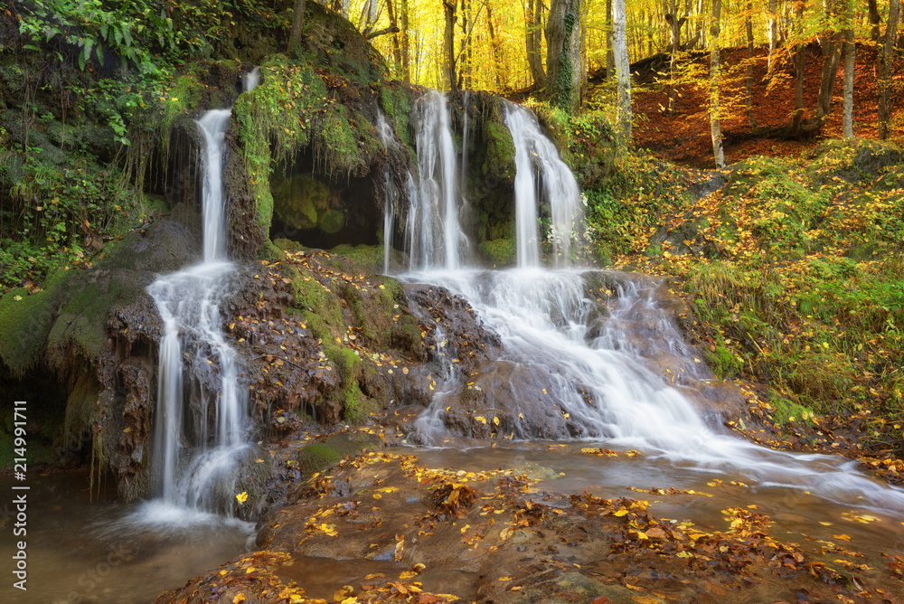 Fototapeta premium Dokuzak waterfall in Strandja mountain, Bulgaria during autumn. Beautiful view of a river with an waterfall in the forest. Magnificent autumn landscape.