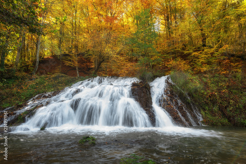 Fototapeta Naklejka Na Ścianę i Meble -  Dokuzak waterfall in Strandja mountain, Bulgaria during autumn. Beautiful view of a river with an waterfall in the forest. Magnificent autumn landscape.