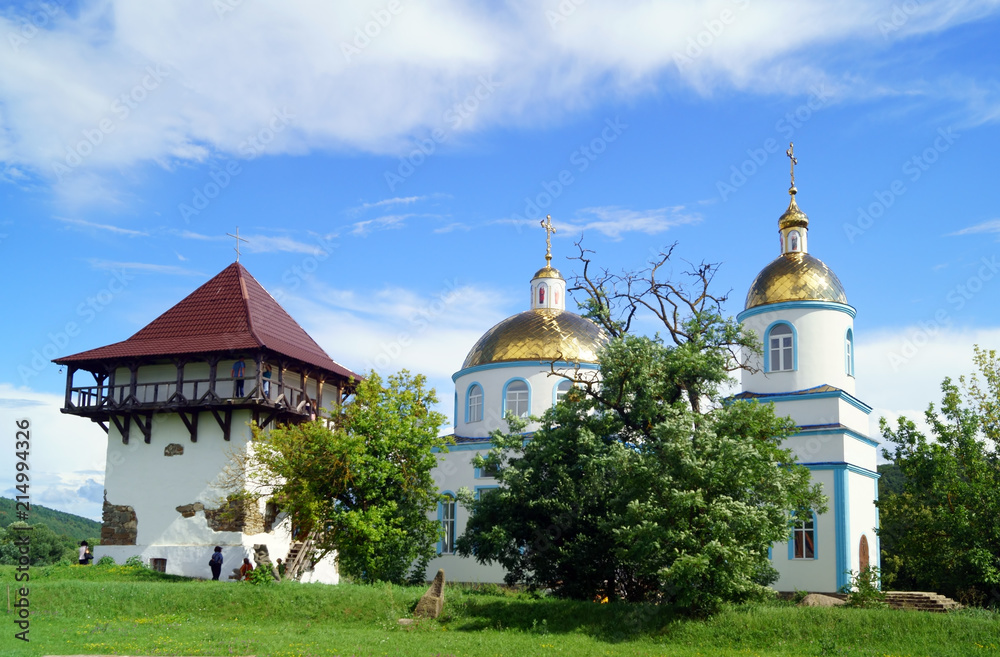Orthodox Church and restored tower of ancient fortress in medieval village Busha, Vinnytsia Oblast, Ukraine.