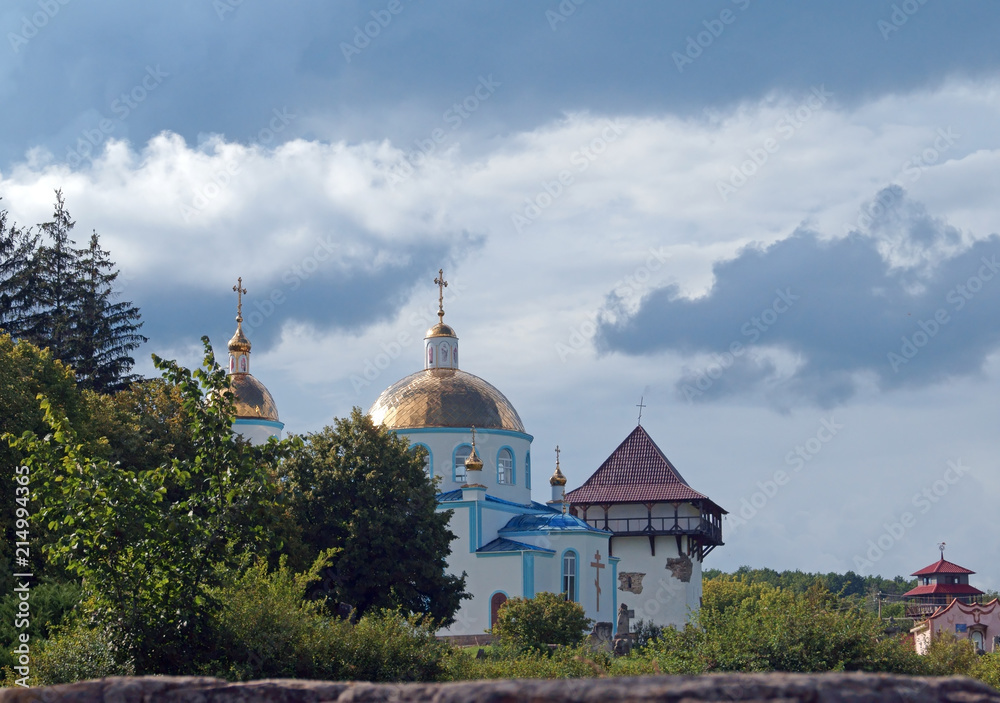 Orthodox Church and restored tower of ancient fortress in medieval village Busha, Vinnytsia Oblast, Ukraine.