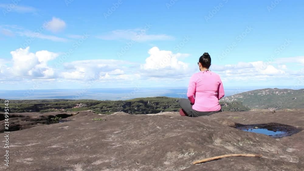 Young girl meditating on the mountains