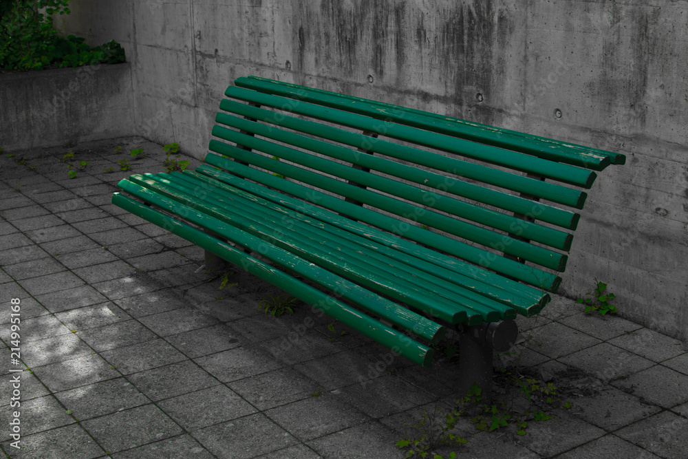 Green bench made of wood in urban environment in the shade to rest on wooden bench with concrete around. Green bench made of wood in urban environment in the shade to rest on wooden bench with concrete around.