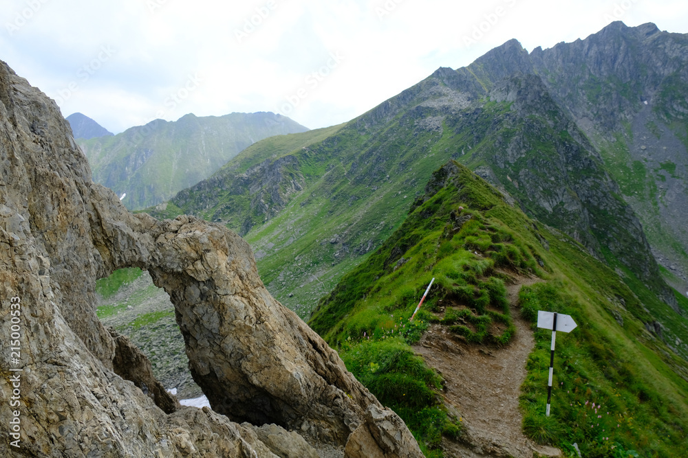 Obraz premium Rumunia, Karpaty Rumuńskie - Góry Fagaras, skalne okno na przełęczy Portiţa Arpaşului