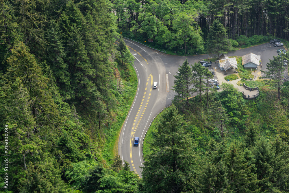 Aerial view of us route 101 at Cape Perpetua Scenic Area with resting area and traffic, winding through pine forest, Oregon, USA. Aerial view of us route 101 at Cape Perpetua Scenic Area with resting area and traffic, winding through pine forest, Oregon, USA.