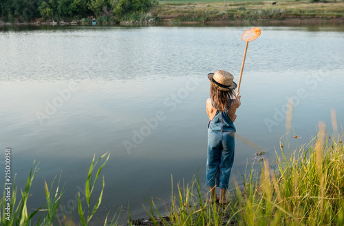 Child with a insect net catches butterfly