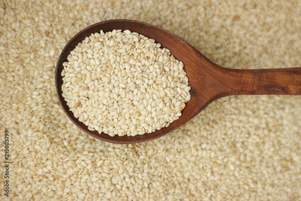 sesame seeds in a wooden spoon sesame seeds in a wooden spoon