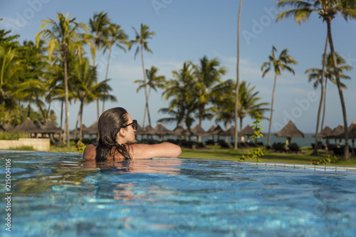 Beautiful brazilian woman enjoying vacation holidays at a pool.