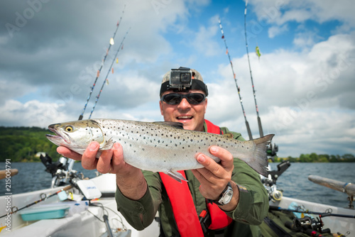Happy angler with summer lake trout