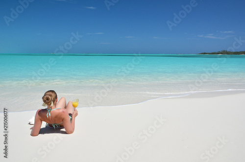 Girl with a glass of orange on the beach of Exuma  Bahamas