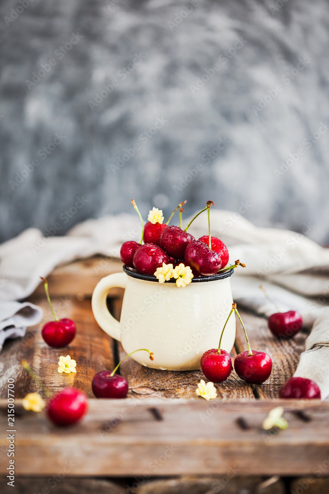 Fresh ripe cherries in a mug on rustic background Fresh ripe cherries in a mug on rustic background