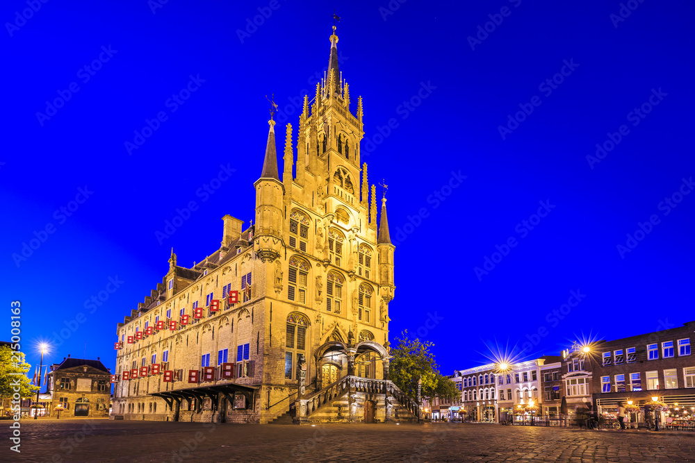 Monumental gothic City hall on the square of historical city Gouda illuminated during dusk