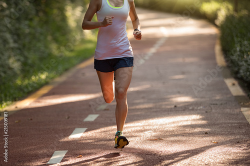 Healthy woman runner running on morning park road workout jogging