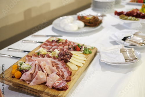 Tagliere di salumi esposti in un tipico buffet italiano con mortadella, formaggio e salame su di una tavola elegante